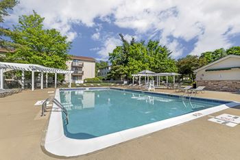 A large outdoor swimming pool with a white fence around it.